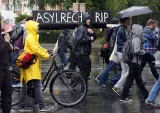 Des manifestants portant un faux cercueil sur lequel est écrit : «?RIP au droit d'asile?», le 20 juin 2015, à Berlin - AFP/ Adam Berry


