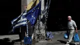 Un homme passe devant des drapeaux grecs et une bannière européene dans une rue du centre d'Athènes, le 13 juillet 2015


