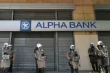 Des forces de police grecques devant l'étalissement bancaire Alpha bank le 8 juillet dernier alors que toutes les banques du pays étaient fermées - AFP PHOTO/ Louisa Gouliamaki


