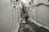 Un touriste dans une rue déserte de Fira, sur l'île grecque de Santorin, le 4 février 2025