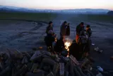Des réfugiés se réchauffent autour d'un feu près du village frontière d'Idomeni en Grèce le 21 janvier 2016.


