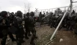 Des migrants tentent de forcer la barrière qui sépare la Grèce de la Macédoine, le 29 février.


