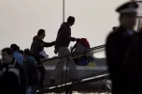 Des migrants embarquent à bord d'un bateau turc dans le port de Mytilène, lundi 4 avril.


