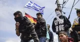 Des réfugiés et des migrants brandissent les drapeaux grec et allemand - Bulent Kilic/AFP


