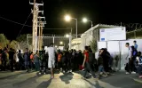 Des migrants devant les portes fermées du camp de Moria, ce lundi. Crédits photo : INTIME/REUTERS


