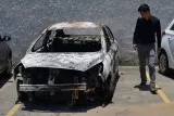 Un homme regarde la voiture de l'ambassadeur grec sur le parking du commissariat, à Rio (Brésil) le 30 décembre 2016.


