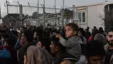 Un homme porte un enfant sur ses épaules lors d'une manifestation de réfugiés et migrants le 14 novembre 2017 à l'extérieur du camp de Moria à Mytilene, sur l'île grecque de Lesbos.


