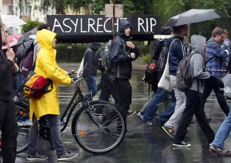 Paris, Berlin et Rome manifestent en soutien aux migrants et à la Grèce Des manifestants portant un faux cercueil sur lequel est écrit : «?RIP au droit d'asile?», le 20 juin 2015, à Berlin - AFP/ Adam Berry