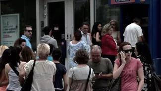Les Grecs se ruent sur les distributeurs après l'annonce du referendum Des grecs, inquiets, retirent leur argent Crédits photo : ARIS MESSINIS/AFP