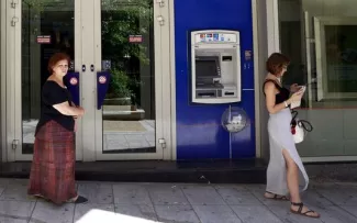 Grèce : Tusk évoque à son tour une restructuration de la dette, les banques fermées jusqu'à lundi Devant un distributeur automatique de billets, à Athènes, le 8 juillet.