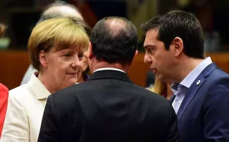 Grèce : à 6h15, le sommet a failli échouer Angela Merke, François Hollande de dos et Alexis Tsipras ce dimanche 12 juillet - AFP PHOTO / JOHN MACDOUGALL
