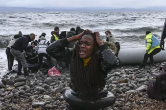 La réaction d'une femme alors que le canot pneumatique transportant 27 réfugiés et migrants originaires de Gambie et de la république du Congo accoste sur l'île de Lesbos, samedi.


