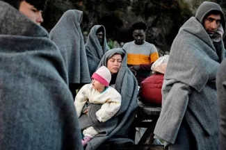 Lesbos se barricade face aux migrants Des migrants arrivés à Lesbos depuis la Turquie jeudi tentent de se réchauffer après avoir passé la nuit dehors sous la pluie. Ils font sécher tant bien que mal leurs vêtements. Image: AFP