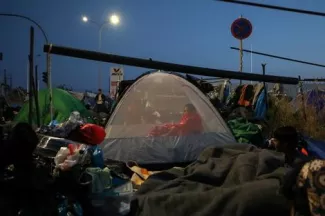 Après l’incendie du camp de Moria, l’Autriche se mobilise pour accueillir 144 réfugiés Une migrante sous l'une des tentes du camp temporaire installé sur l'île grecque de Lesbos, le 14 septembre 2020. REUTERS/Elias Marcou