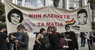 La Grèce à un tournant autoritaire? Des militants tiennent une banderole sur laquelle on peut lire «Ne fermez pas les yeux» près d'un tribunal à Athènes, le 21 octobre 2020, au début du procès concernant la mort de Zak (Zackie) Kostopoulos. — © LOUISA GOULIAMAKI / AFP