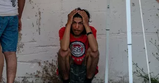 En Grèce, la politique migratoire au centre des débats : "On se demande si l’UE existe encore" Un survivant du naufrage devant l'entrepôt où ils sont hébergés dans le port de Kalamata, en Grèce, le 14 juin 2023