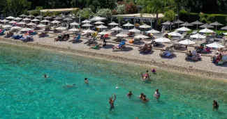 Plus la Grèce devient touristique, moins elle reste la Grèce Sur la plage Barbati, à Corfou, le 30 juin 2022. Photo Adonis Skordilis/REUTERS