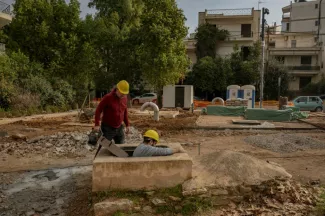 Christos Geovanopoulos (g), responsable du projet de l'aqueduc d'Hadrien à la municipalité de Halanadri, et Yannis Dafnos, géologue, entrent dans un bassin de décantation faisant partie de l'aqueduc d'Hadrien, à Chalandri, dans la banlieue d'Athènes, le 27 janvier 2025  -  Angelos TZORTZINIS - Chalandri (AFP)