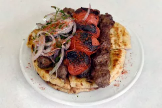 Une assiette du grand classique de la street food grecque : le souvlaki ; dans le restaurant Kebab-Souvlaki du quartier de Monastiraki, à Athènes, en 2014. LOUISA GOULIAMAKI / AFP