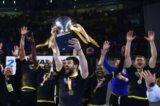 Autour du capitaine grec Evangelos Arampatzis, les Français de l'AEK Frédéric Beauregard, Adama Sako, Dylan Garain (masqué), Souleymani Touré, Yann Genty (en bleu) et Lukas Genes (de g. à dr.) fêtent la conquête de la Coupe de Grèce, le 12 avril. (Eurokinissi sports)