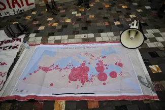 Une carte des naufrages de migrants déployée lors d'une manifestation de soutien aux victimes sur laquelle est écrite « Pylos était un meurtre de masse perpétré par l'Etat grec et l'Union européenne ». A Athènes, le 28 juin 2023. LOUISA GOULIAMAKI/AFP