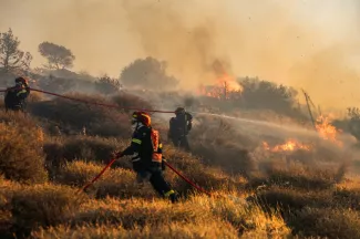 Des pompiers luttent contre le feu près de Ierapetra sur l'île grecque de Crète, le 3 juillet 2025 - Costas Metaxakis - Ierapetra (AFP)