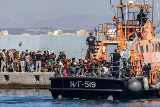 Des migrants sauvés en mer, dans le port d'Agia Galini, en Crète, le 6 juillet 2025. COSTAS METAXAKIS/AFP