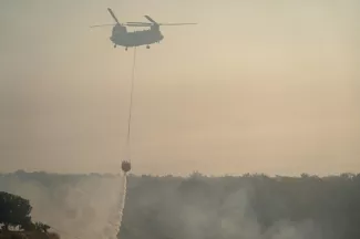 Un hélicoptère participe aix opérations pour éteindre les flammes après un feu de forêt dans le village chypriote de Souni, dans la province de Limassol, le 24 juillet 2025 - Etienne TORBEY - Soúni (AFP)