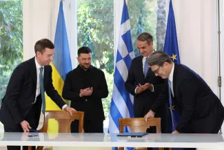 Le président ukrainien, Volodymyr Zelensky (à gauche) et le premier ministre grec, Kyriakos Mitsotakis (à droite), applaudissent Serhi Koretsky, directeur général de la Compagnie nationale ukrainienne d'électricité Naftogaz (à gauche), et Konstantinos Xifaras, directeur général de DEPA SA (à droite), après la signature d'un accord au palais Maximos d'Athènes, le 16 novembre 2025. YORGOS KARAHALIS/AP