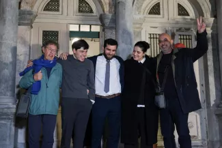 Sean Binder (2ᵉ à gauche) en compagnie d'autres travailleurs humanitaires engagés dans le sauvetage de réfugiés, après leur acquittement, à Mytilène, en Grèce, le 15 janvier 2026. ELIAS MARCOU/REUTERS