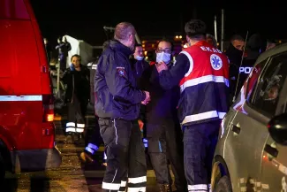 Des secouristes sur le port de l'île de Chios (Grèce), après la collision entre un bateau de migrants et un navire des garde-côtes grecs, le 4 février 2026. AFP