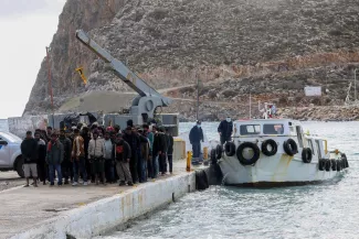Des migrants sur le port de Kaloi Limenes, en Crète (Grèce), le 21 février 2026. STEFANOS RAPANIS/REUTERS