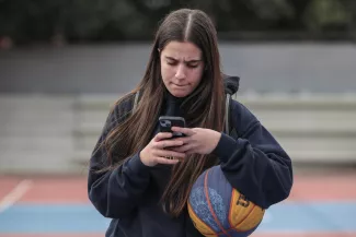 Catherine Daniil, 14 ans, sur son téléphone à Athènes, le 26 février 2026. LOUISA GOULIAMAKI/REUTERS