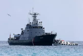 Un transfert de migrants secourus en mer, d’un navire de Frontex vers un plus petit bateau, au large de la Crète (Grèce), le 21 février 2026. STEFANOS RAPANIS/REUTERS