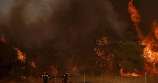 Des pompiers combattent le feu à Loumpa, dans la région grecque de l'Attique, le 3 août 2026.