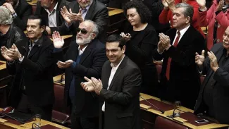 Comment le «Mélenchon grec» compte redresser l'économie du pays Alexis Tsipras au premier plan applaudissant les résultats du second tour de l'élection présidentielle à Athènes