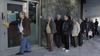 Des retraités attendent de pouvoir retirer leur pension au guichet d'une banque. Crédits photo : Petros Giannakouris/AP


