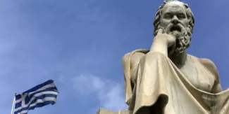 La BCE relève encore le plafond de son financement d'urgence des banques grecques Le drapeau grec flotte à côté d'une statue de Socrate, à Athènes, le 18 mars.