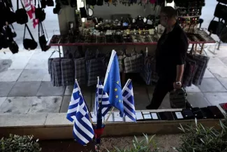 Les négociations sur la Grèce se terminent à Bruxelles sans accord Trois drapeaux grecs et un drapeau européen près du port du Pirée à Athènes, le 14 juin 2015 (Photo ANGELOS TZORTZINIS. AFP)