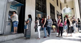 Le sort des banques grecques ne tient plus qu'à un fil Pour éviter les retraits massifs (ici, samedi dernier à Thessalonique), une fermeture des établissements bancaires est envisagée. - Photo Giannis Papanikos/AP/Sipa