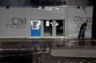 Normalisation économique en Grèce Un homme nettoie la chaussée devant une banque à Athènes encore fermée. Image: Archives/Reuters
