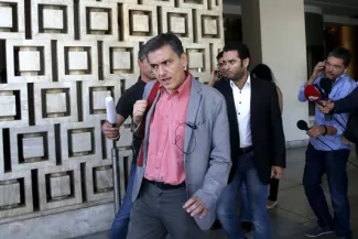 Euclide Tsakalotos, ministre des finances grec quitte l'hotel où ont eu lieu les négociations avec les représentants du Fonds Monétaire International, le 11 août.


