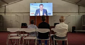 Grèce : Aléxis Tsípras pris entre deux feux Pourtant de courte durée, la campagne électorale ne mobilise pas les foules. Quelques hommes regardent le débat télévisé diffusé mercredi soir sur les télévisions grecques. - AFP/ LOUISA GOULIAMAKI