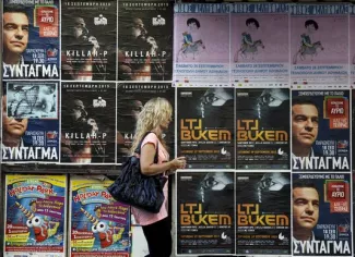 En Grèce, un paysage politique bouleversé par la crise Une femme passe devant des affiches, dont celles de Syriza, le 18 septembre à Athènes, en Grèce.