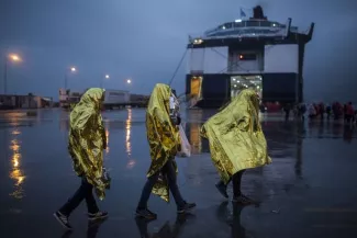 En Grèce, arrestation de cinq bénévoles ayant aidé des migrants Au nord de l'île de Lesbos, sur les côtes où débarquent chaque jour des dizaines de barques de réfugiés, une multitude de petits camps de transit ont vu le jour, offrant un abri de quelques heures avant le transfert vers la capitale, Mytilène.
