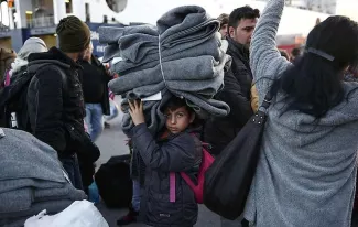 La crise des migrants du Proche Orient, illustrée par cet enfant portant des couvertures au port du Pirée en Grèce, menace la cohésion de l'Union européenne. - Yorgos Karahalis/AP/SIPA


