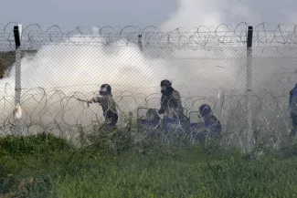 La police macédonienne, de l'autre côté du grillage marquant la frontière entre la Grèce et la Macédoine, lors des heurts avec les migrants, le 10 avril.


