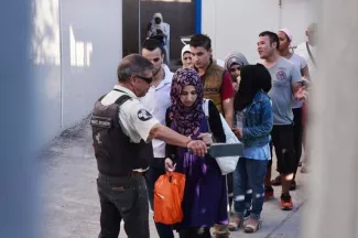 A Athènes, des migrants à l'entrée des services d'asile, le 22 août.


