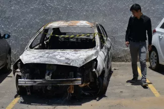 L'ambassadeur grec assassiné par un policier Un homme regarde la voiture de l'ambassadeur grec sur le parking du commissariat, à Rio (Brésil) le 30 décembre 2016.