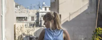 Noemi Niederhauser au balcon de sa maison de Kypseli à Athènes. © Socrates Baltagiannis


